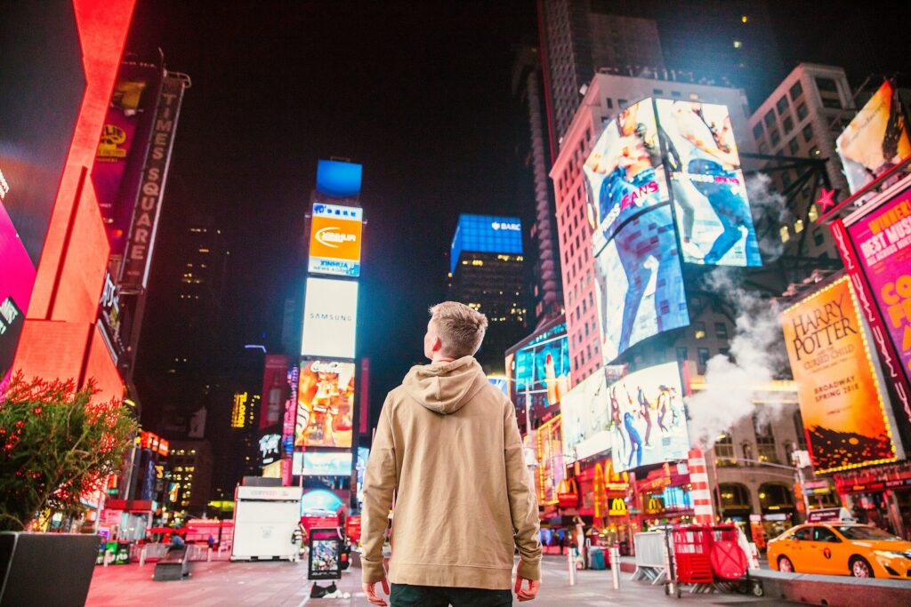 pedestrian looking up at advertisements